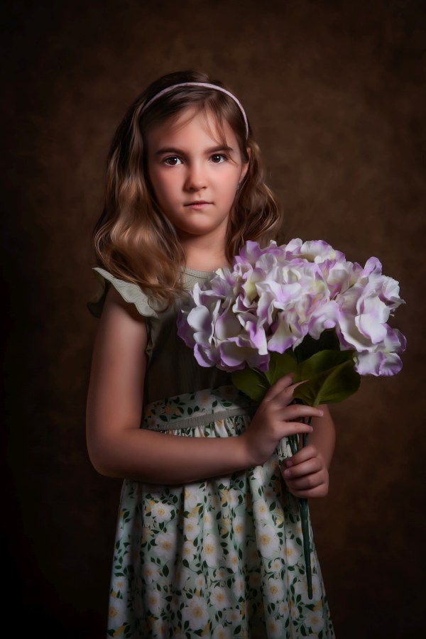 Fineart fotózás, festményi stílusban a kislány áll és fog egy csokor nagyfejű virágot