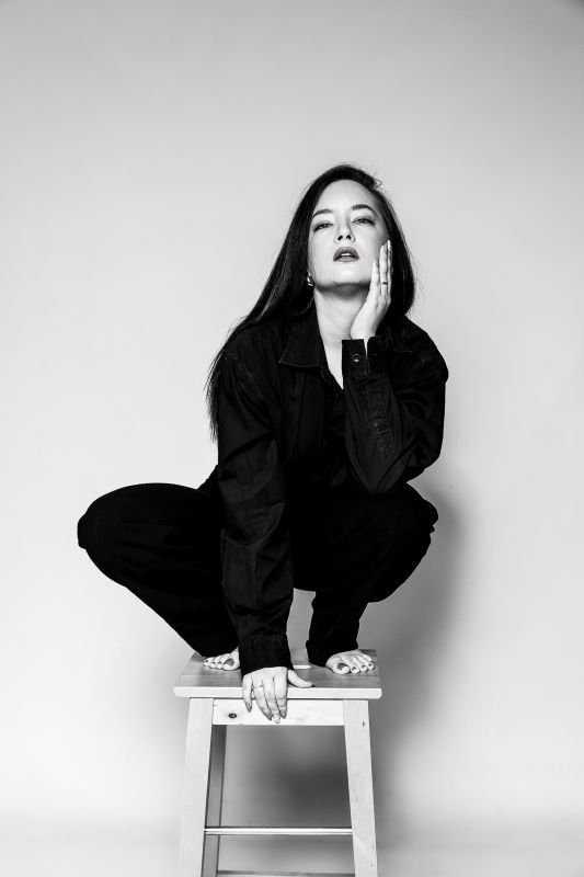 Modell portfólió fotózás fekete hátteres fehérneműs fotózás ízléses, földön fekvő pózban - debrecen stúdióban