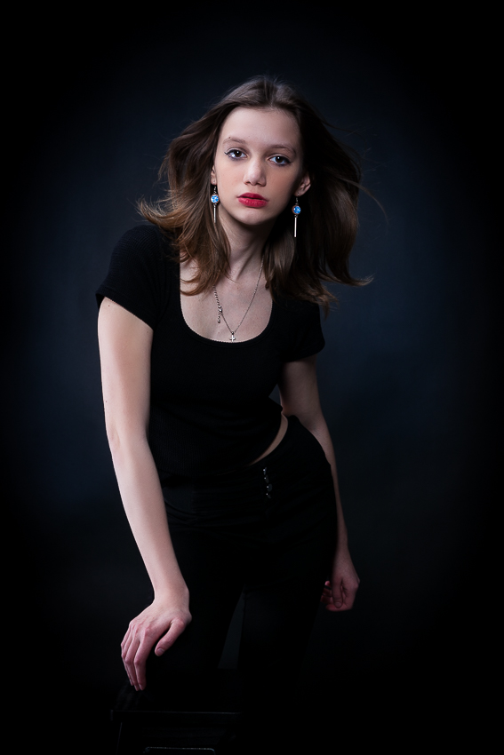 modell ül a széken és oldalra fordulva pózol harisnyában és bodyban - portfólió készítés debrecen