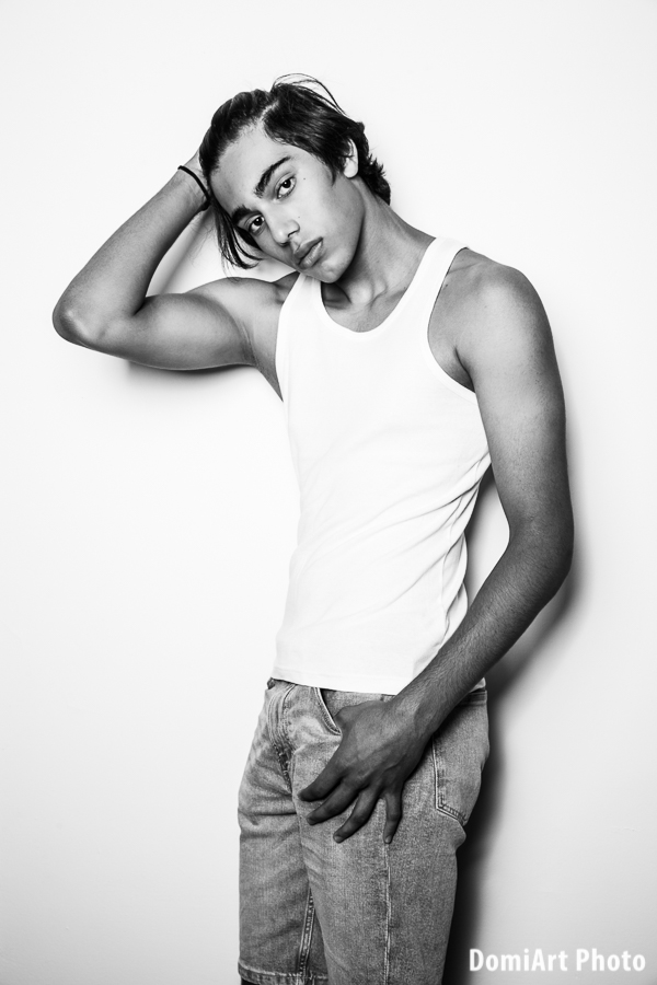 félvér srác férfi portfólió készítés mátrix fotózásán, fehér atléta, farmer, fehér fal melletti pózolás