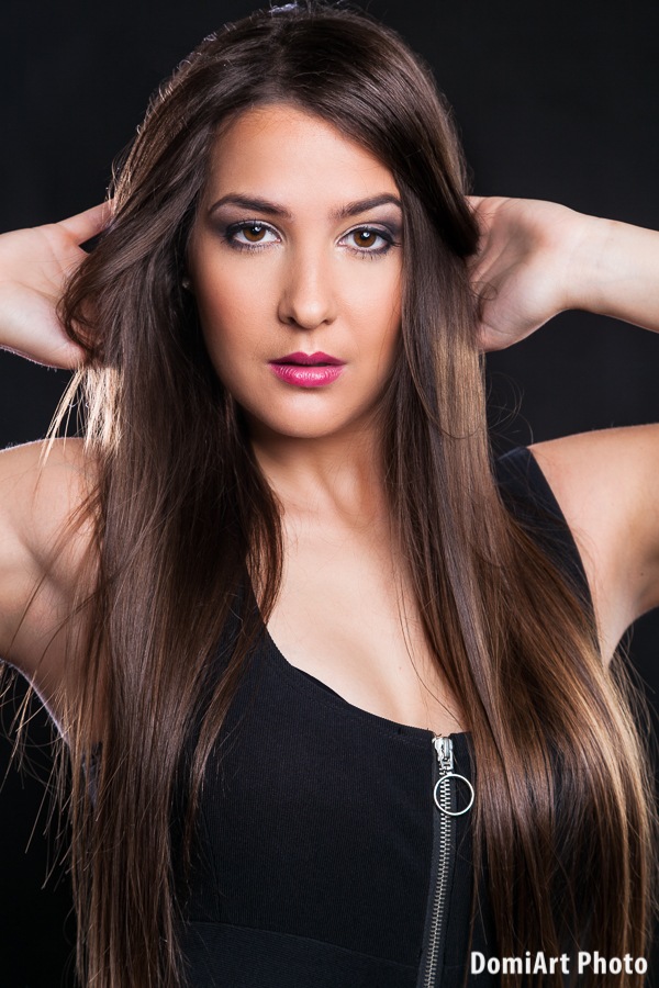 hosszú barna hajú modell, közeli portréfotózás, fekete ruhában arany szegéllyel